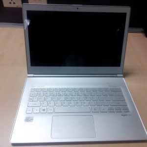 لابتوب فضي مفتوح على مكتب خشبي فاتح